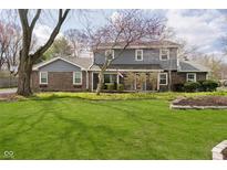 Charming two-story home with landscaped front yard, brick accents, and mature trees at 9270 N Temple Ave, Indianapolis, IN 46240
