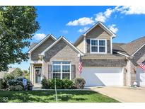 Charming two-story home features a brick facade, attached garage, and beautifully landscaped front yard on a sunny day at 10955 Chapel Woods N Blvd, Noblesville, IN 46060