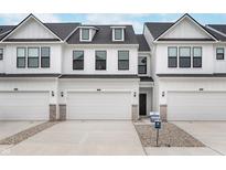 Charming townhome featuring a white exterior, attached garage, and well-maintained landscaping at 10965 Morab Dr, Zionsville, IN 46077