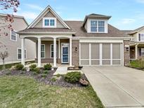 Charming two-story home with a brick and siding facade, covered porch, and well-maintained landscaping at 12521 Hawks Landing Dr, Fishers, IN 46037