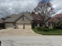 A brick home with a three car garage and mature trees at 1304 Park Meadow Dr, Beech Grove, IN 46107