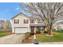Charming two-story home with a well-manicured lawn, blossoming tree, and red-shuttered windows at 24 W Pine Ridge Dr, Westfield, IN 46074