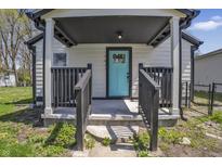 Inviting front porch featuring a vibrant blue door and classic black railings at 2631 Collier St, Indianapolis, IN 46241
