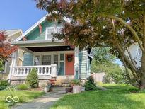 Charming home featuring a covered front porch and lush landscaping at 37 N Arlington Ave, Indianapolis, IN 46219