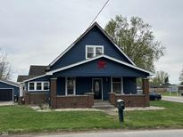 Charming home featuring a covered porch with brick supports and a prominent star decoration at 389 W Poston Rd, Martinsville, IN 46151