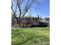 Charming two-story brick home with a manicured lawn and mature landscaping creating great curb appeal at 3911 E 75Th St, Indianapolis, IN 46240