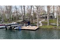 Waterfront property with a private dock featuring boat slips and a lakeside lounging area at 7014 Eagle Dr, Nineveh, IN 46164