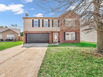 Charming two-story home featuring a brick and vinyl exterior, attached garage, and well-maintained front lawn at 8813 Browns Valley Ln, Indianapolis, IN 46113