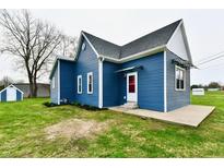 Charming blue home featuring a new roof, fresh landscaping, and a matching storage shed at 10880 N 23Rd St, Elwood, IN 46036