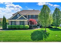 Charming two-story home with a well-manicured lawn, lush landscaping, and a brick facade at 11509 Wildlife Ct, Zionsville, IN 46077