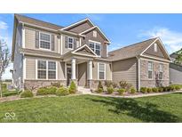 Charming two-story home featuring a covered porch and well-maintained landscaping, perfect for curb appeal at 12894 Corydon Dr, Fishers, IN 46037