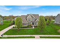 Beautiful two-story home featuring lush green lawn, mature trees, and tasteful landscaping at 1533 Windswept, Brownsburg, IN 46112