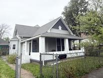 Charming home featuring a covered front porch, gray roof, and white painted brick at 2208 Avondale Pl, Indianapolis, IN 46218