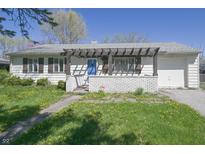 Charming single-story home with a blue door, brick accents, and a well-lit front yard at 3550 Winings Ave, Indianapolis, IN 46221