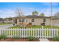 Charming single-story home featuring a front porch, white picket fence, and well-maintained lawn at 409 W Pike St, Martinsville, IN 46151