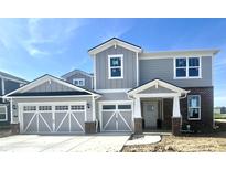 Two-story home with a two-car garage, grey siding and a brick entryway with white trim offers charming curb appeal at 827 Allandale Ave, Westfield, IN 46074