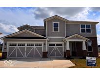 Charming two-story home featuring a three-car garage, gray siding, and a welcoming covered porch at 827 Allandale Ave, Westfield, IN 46074