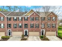 Charming red brick townhomes featuring black shutters, individual garages and well-maintained landscaping at 967 Orlando St, Carmel, IN 46032
