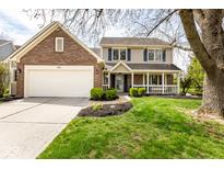 Charming two-story home featuring a brick and siding exterior, attached garage, and covered front porch at 9812 Logan Ln, Fishers, IN 46037