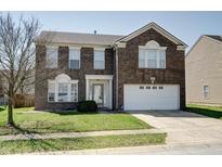 Two-story brick home with attached two-car garage and well-maintained lawn at 10597 Cyrus Dr, Indianapolis, IN 46231