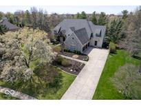 Stunning two-story brick home with a three-car garage, long driveway, and lush landscaping at 10628 Walnut Creek W Dr, Carmel, IN 46032
