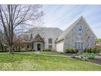 Beautiful home featuring stone and brick exterior, manicured lawn and professional landscaping at 10628 Walnut Creek W Dr, Carmel, IN 46032