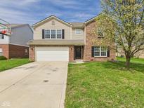 Charming two-story home boasts a brick and tan siding exterior with an attached two-car garage at 11840 Geyser Ct, Fishers, IN 46038