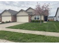 Charming single-story home featuring an attached garage, beautiful lawn, and blossoming tree at 1302 Lexington Trl, Greenfield, IN 46140