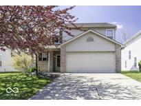 Charming two-story home featuring a two-car garage, landscaped yard and blooming tree in a well-maintained neighborhood at 1328 Osprey Way, Greenwood, IN 46143