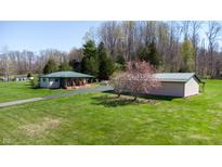 Charming home with a green metal roof, matching outbuilding, and a spacious lawn at 2455 Lenvoil Rd, Martinsville, IN 46151
