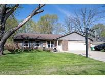 Charming brick home with a well-manicured lawn, front porch, two-car garage, and basketball hoop at 30 Sleepy Hollow Ct, Westfield, IN 46074
