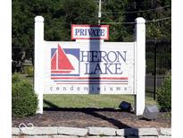 Private Heron Lake Condominiums sign with sailboat and lake in front of a wooded area at 3010 Lake Shore Dr # D, Indianapolis, IN 46205