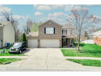 Charming two-story home with a brick facade, two-car garage, and well-maintained front yard at 3038 Arrowroot Ln, Indianapolis, IN 46239