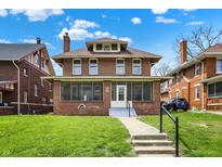 Charming two-story brick home with a covered front porch and well-maintained lawn at 3140 N Washington Blvd, Indianapolis, IN 46205