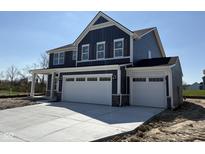 A beautiful two-story home featuring a three-car garage and blue siding and a concrete driveway at 338 Mcnair Dr, Whiteland, IN 46184
