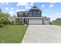 Beautiful two-story home with a three car garage, red door, and manicured lawn on a sunny day at 338 Mcnair Dr, Whiteland, IN 46184
