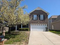 Charming two-story brick home featuring a manicured front yard and an attached garage at 3930 Towhees Dr, Indianapolis, IN 46237