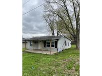 Charming single-story home featuring a covered front porch and mature trees, perfect for quiet evenings at 4206 Clark St, Anderson, IN 46013
