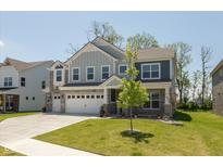 Inviting two-story home featuring a lush lawn, three-car garage and stone accents at 4333 Ironclad Dr, Bargersville, IN 46106