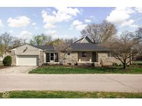 Charming ranch-style home with stone exterior and attached two-car garage at 5802 Crittenden Ave, Indianapolis, IN 46220