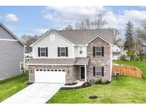 Charming two-story home features a brick facade, attached two-car garage, and manicured front lawn at 605 Tuscany Trl, Lapel, IN 46051