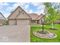 Charming brick home featuring a two-car garage, manicured lawn, and inviting curb appeal at 7113 Lakeside Woods Dr, Indianapolis, IN 46278