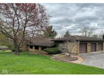 Attractive stone facade on this home with an attached two car garage and a beautifully landscaped front yard at 8801 Ridge Hill Dr, Indianapolis, IN 46217
