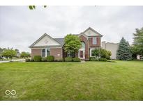 Charming brick two-story home with a well-manicured lawn and mature landscaping at 11648 Stickney Ct, Fishers, IN 46037