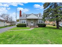 Charming stone-clad home with a well-maintained lawn and mature tree in a residential neighborhood at 1194 S Faculty Dr, Indianapolis, IN 46241