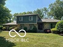 Charming two-story home with a stone facade and a well-manicured front lawn at 13892 Adios Pass, Carmel, IN 46032