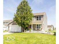 Charming two-story home with a well-manicured lawn and inviting front porch seating at 3896 Woods Bay Ln, Plainfield, IN 46168