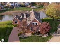 Beautiful brick home with meticulous landscaping, water view, and brick paver driveway at 4052 Diamond Row, Greenwood, IN 46143