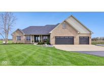 Charming brick home featuring an attached garage, covered porch, and well-manicured lawn at 4634 E 1000 N, Pittsboro, IN 46167