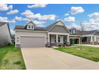 Well-maintained home with a two-car garage, a covered entryway, and coordinated landscaping for curb appeal at 5309 Spyglass Dr, Whitestown, IN 46075